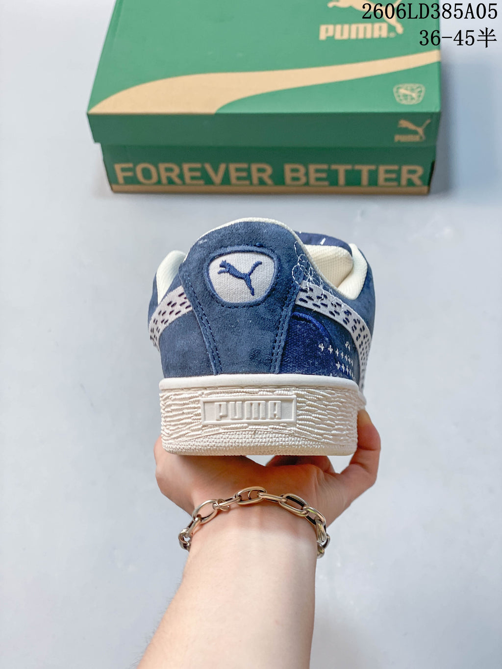 Rear view of a blue PUMA sneaker showing the heel logo and textured off-white sole.