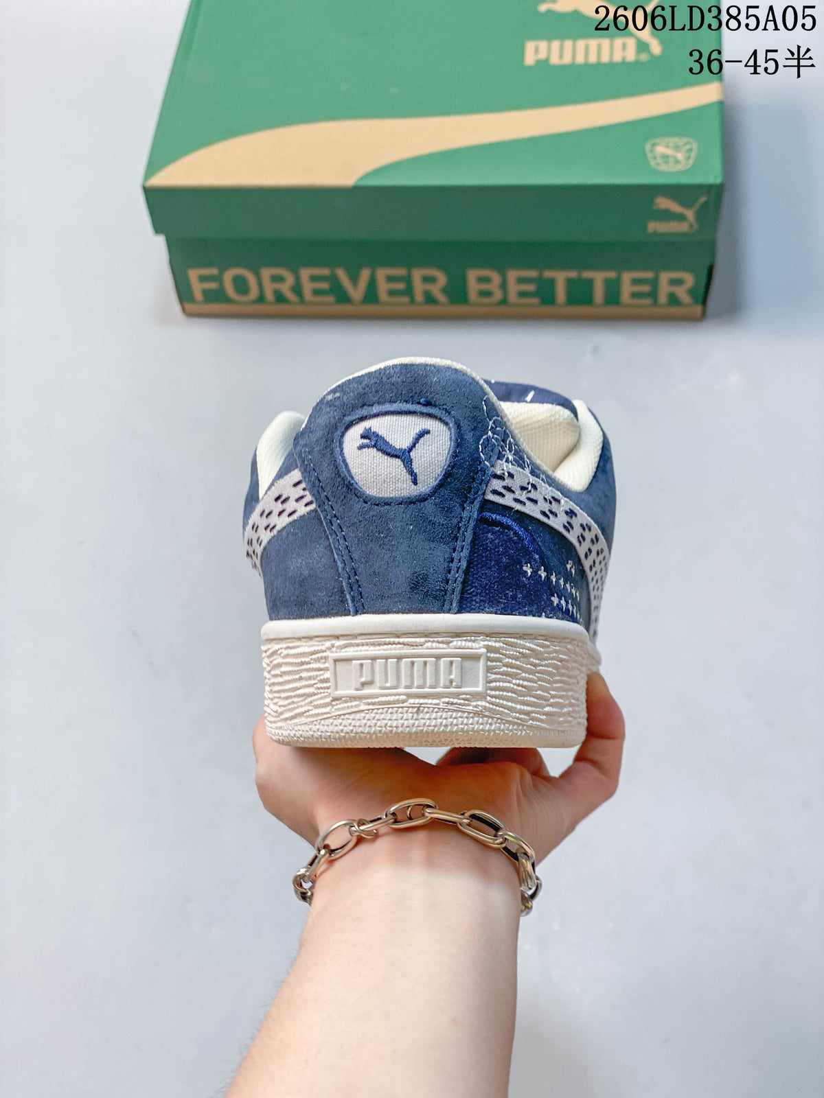 Rear view of a blue PUMA sneaker showing the heel logo and textured off-white sole.