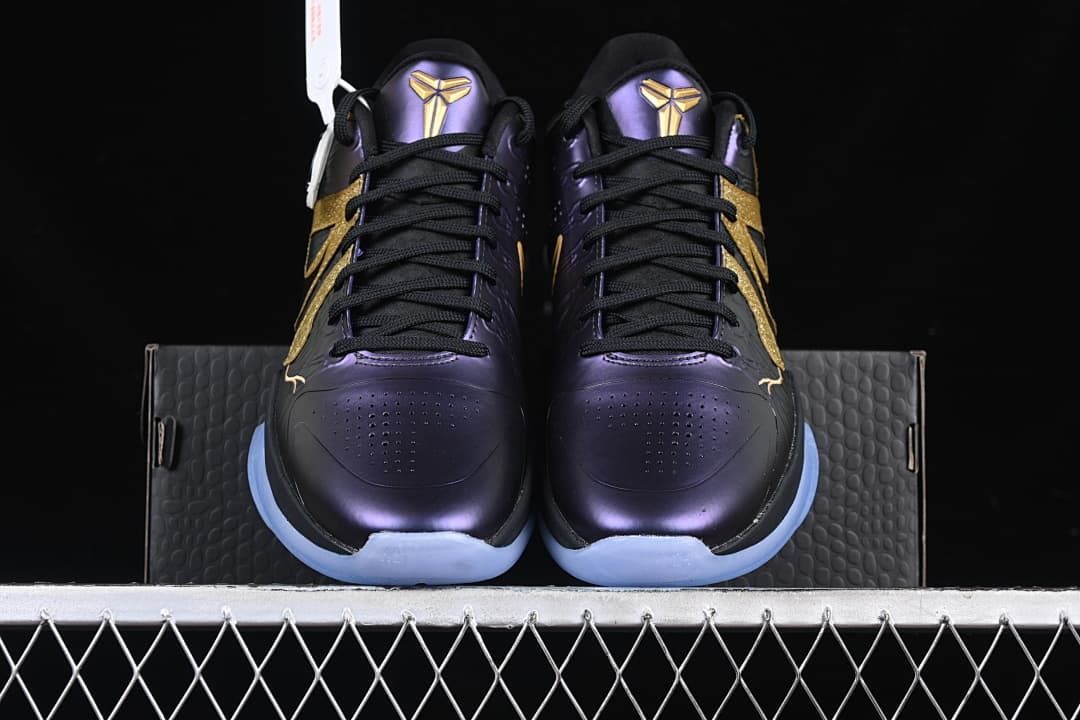 Front view of the pair showing purple toes, black laces, gold accents, and pale blue outsoles