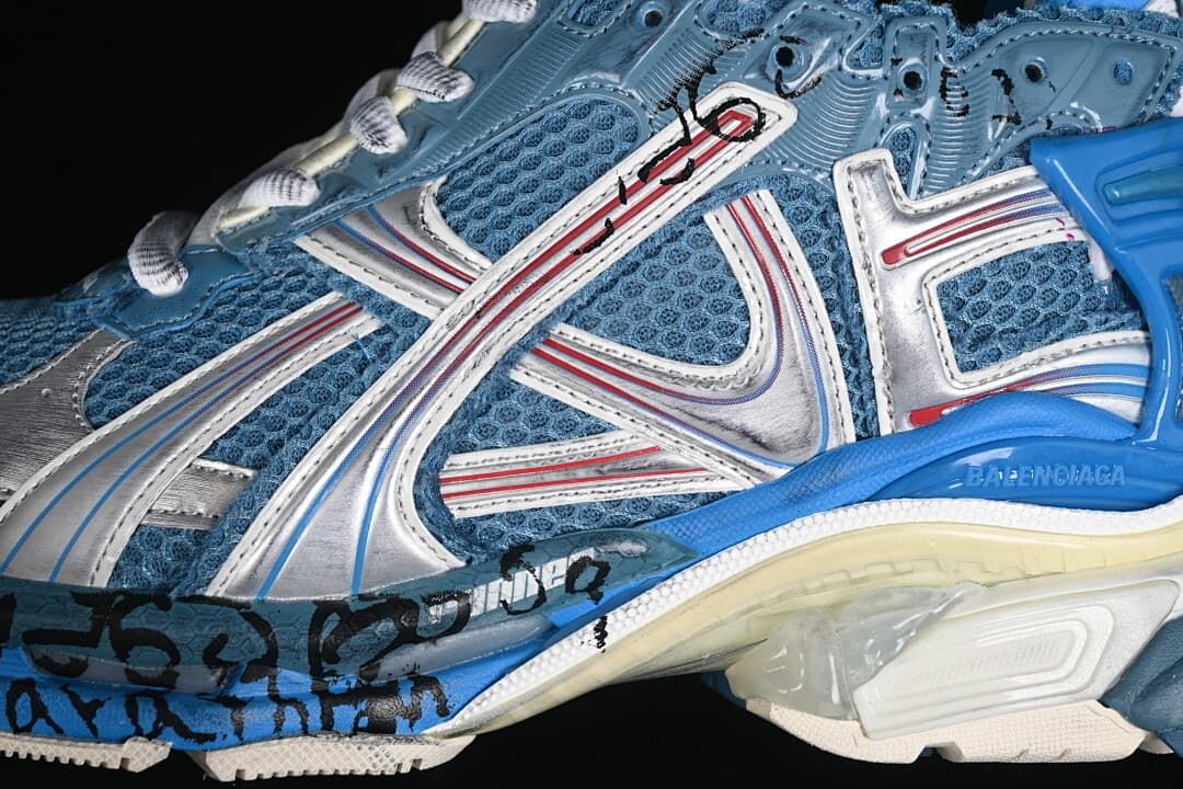 Close-up of silver-toned overlays, blue mesh panels and red detailing