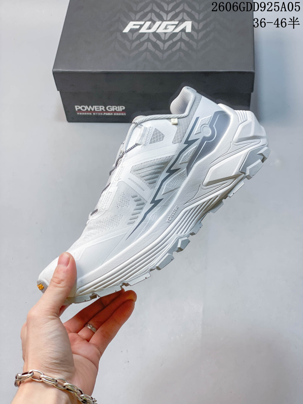 Side view of the white and gray hiking shoe with its thick sole and lugged tread.