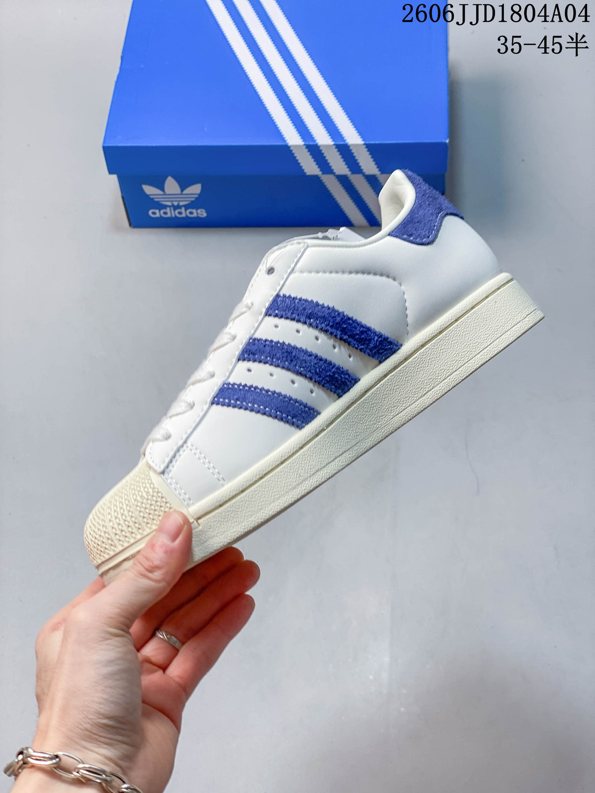 Side view of the white sneaker with three blue stripes and a cream-toned sole