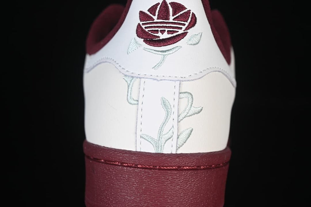 Rear view showing embroidered heel branding and burgundy sole and trim.