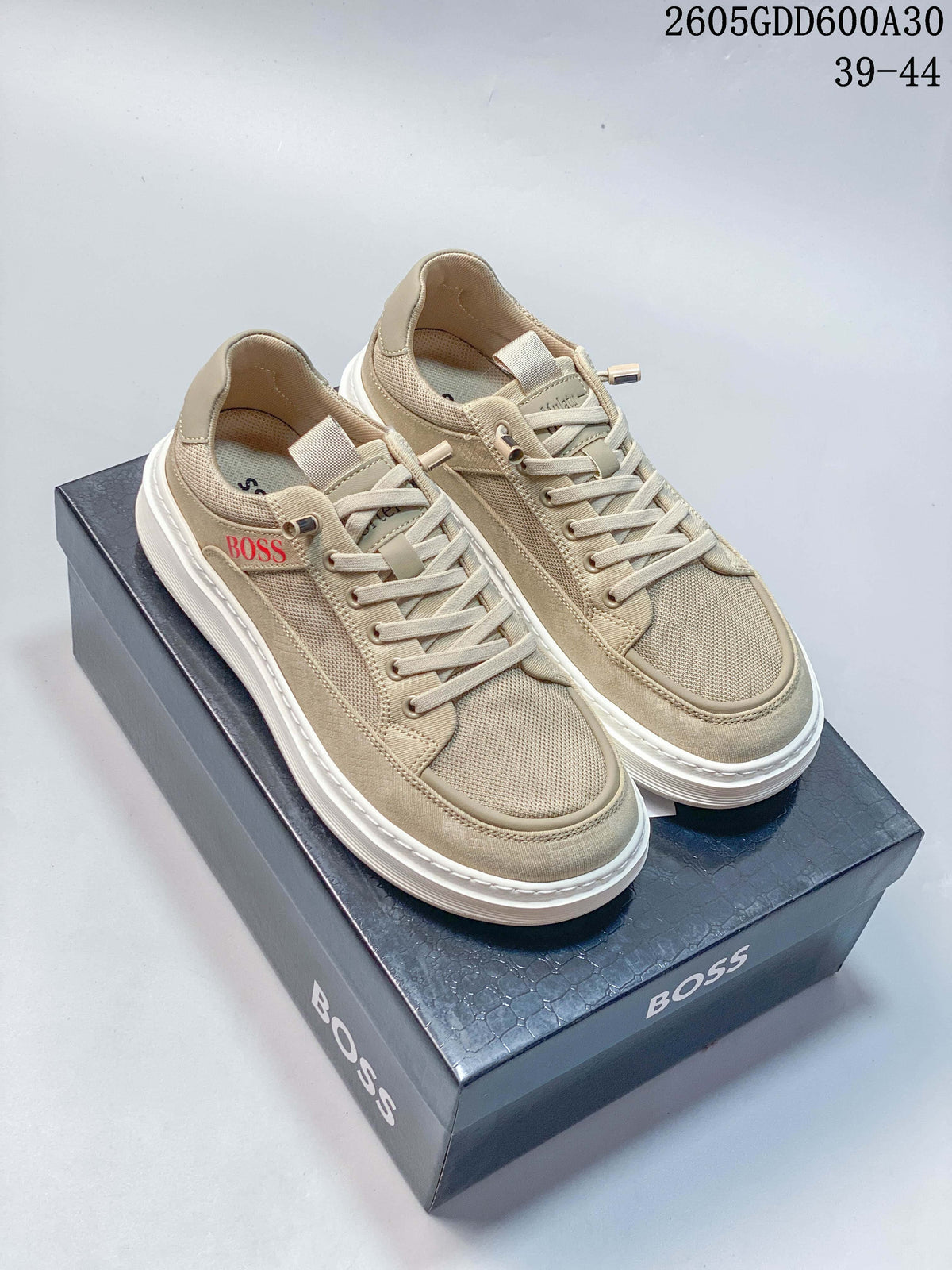 Pair of beige BOSS low-top sneakers on a branded shoebox