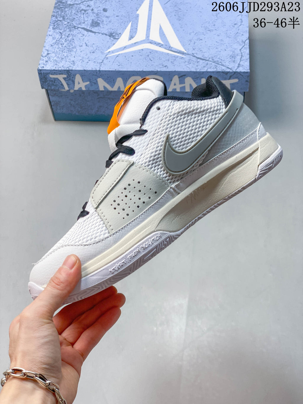 Side view of the white and gray Ja 1 EP shoe with mesh-patterned panels.