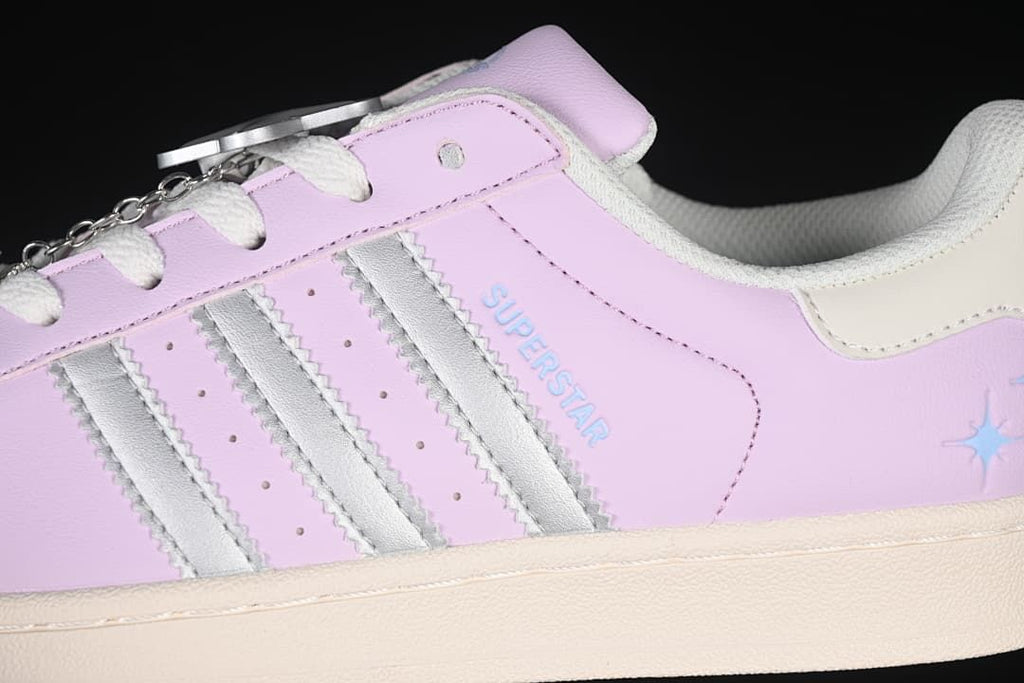Close-up of lilac-pink upper, silver stripes, and Superstar lettering