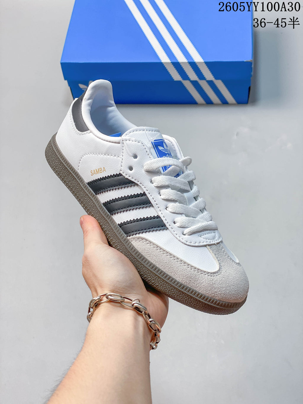 Side view of a white Adidas Samba sneaker with dark stripes and a gum-look outsole