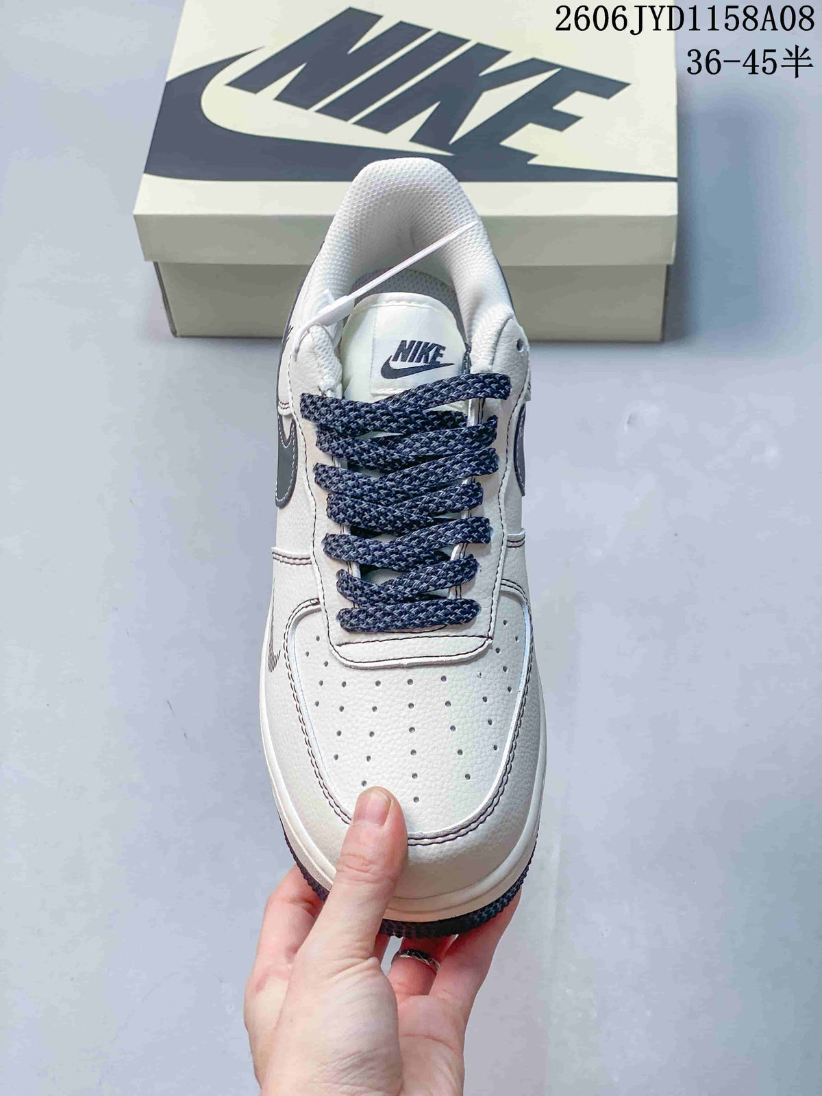 Top view of the sneaker showing its perforated toe, white upper, and navy patterned laces.