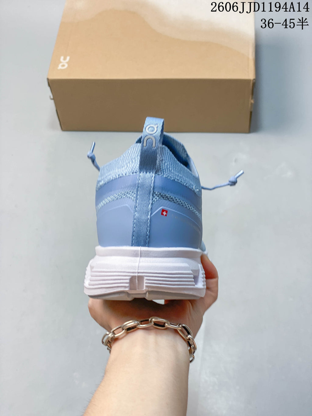 Rear view of a blue sneaker with a heel pull tab and white outsole.