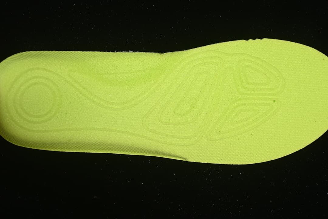 Bright lime-colored insole or footbed shown by itself.