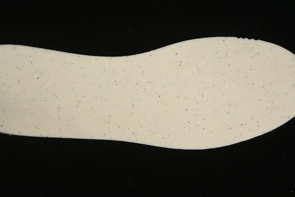 Close-up of a light-colored sneaker insole with small multicolor speckles