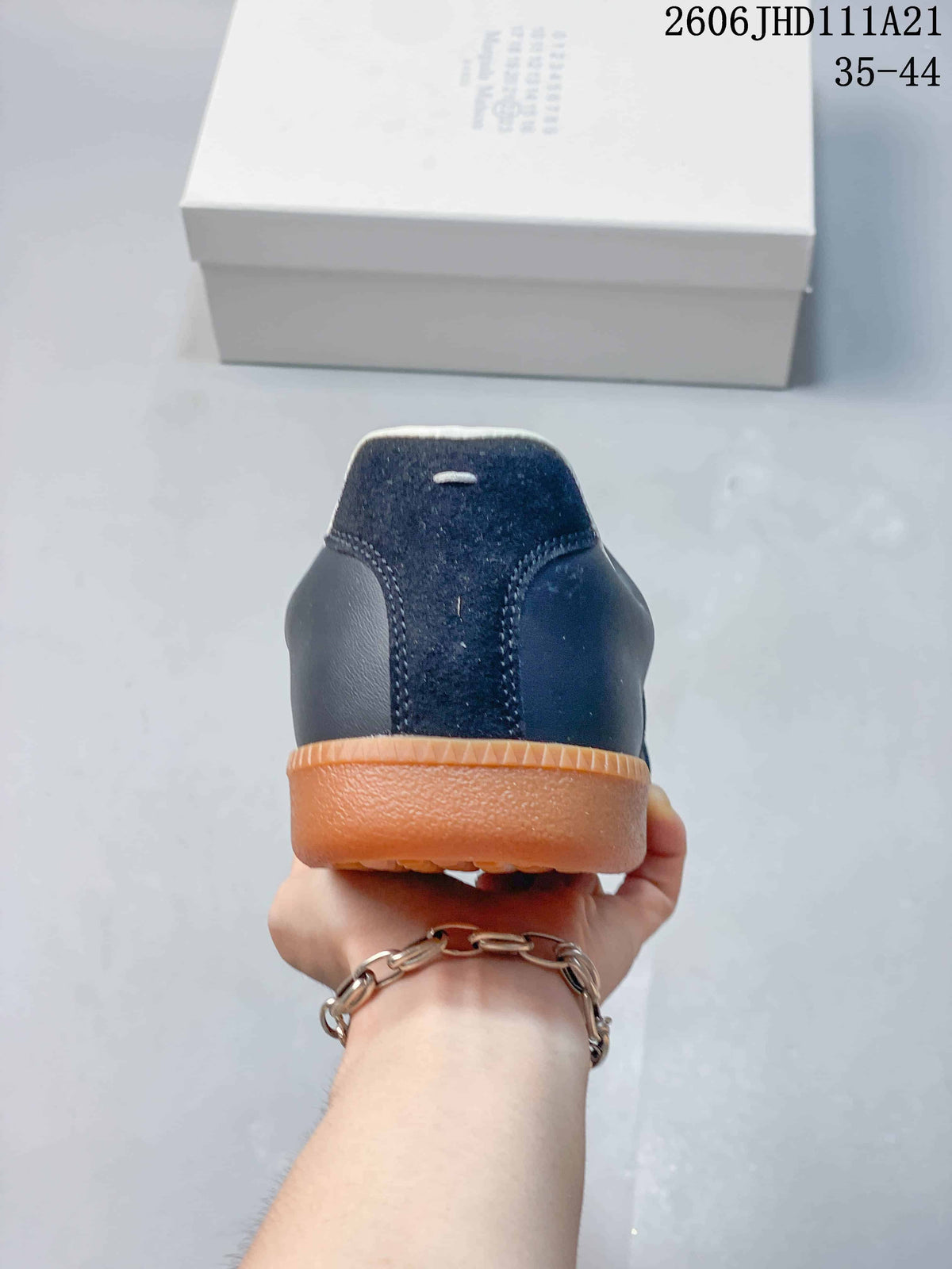 Rear view of the sneaker with navy panels and a gum-colored sole