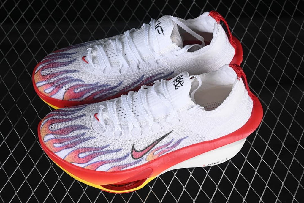 Pair of white Nike running shoes with colorful flame-style graphics