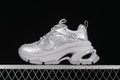 Side view of a silver lace-up sneaker with a chunky sculpted platform sole.