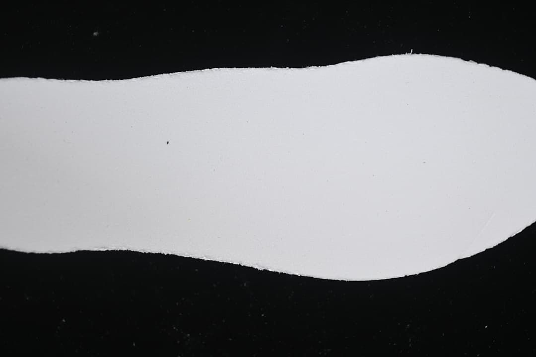 Plain white shoe-shaped insert against a dark background.