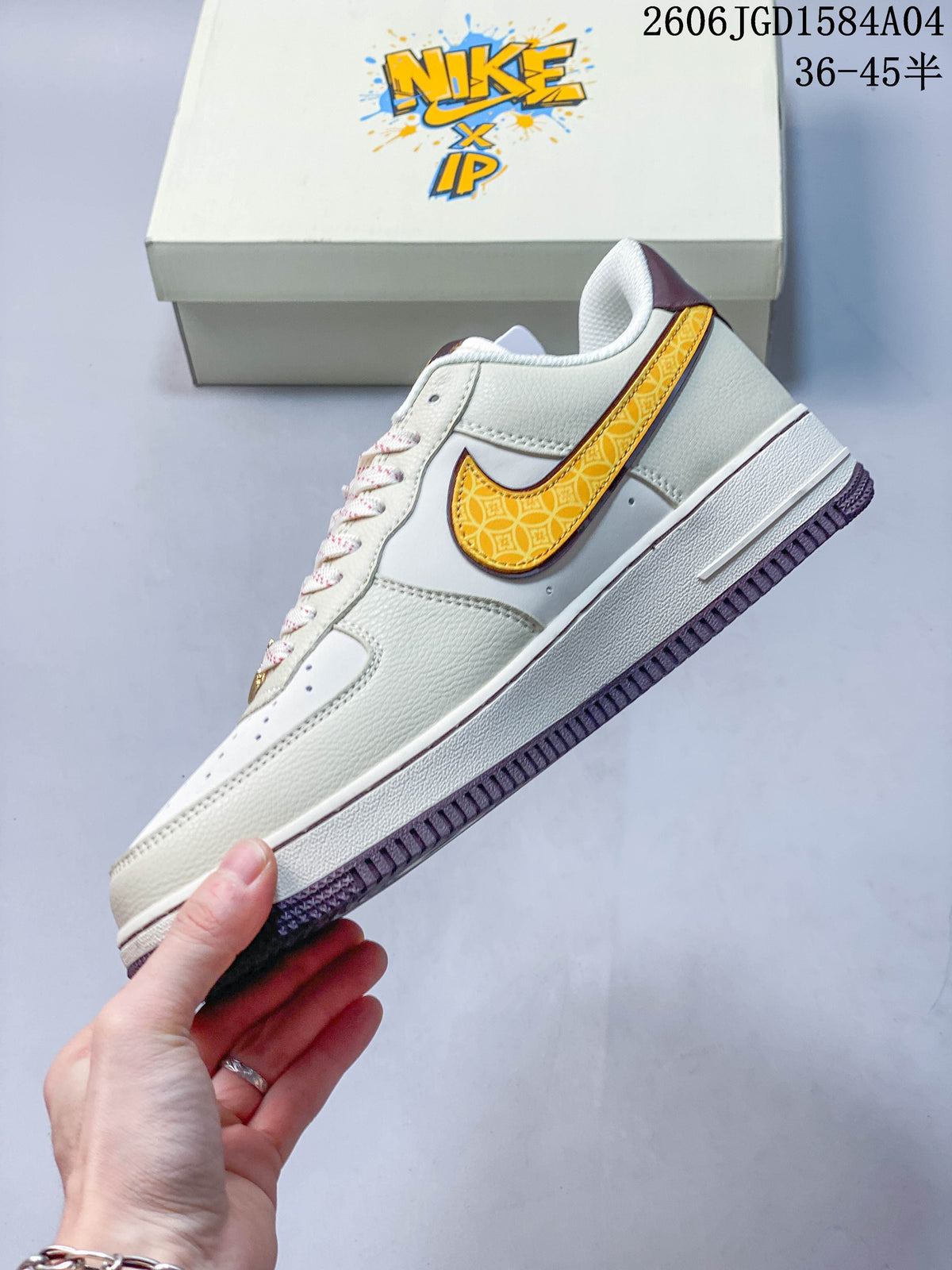 Side view of the ivory sneaker with a patterned gold side logo