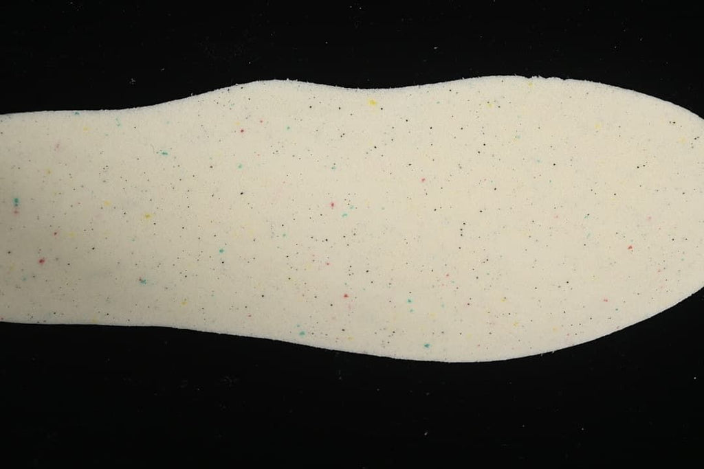 Light-colored sneaker insole with scattered colored flecks