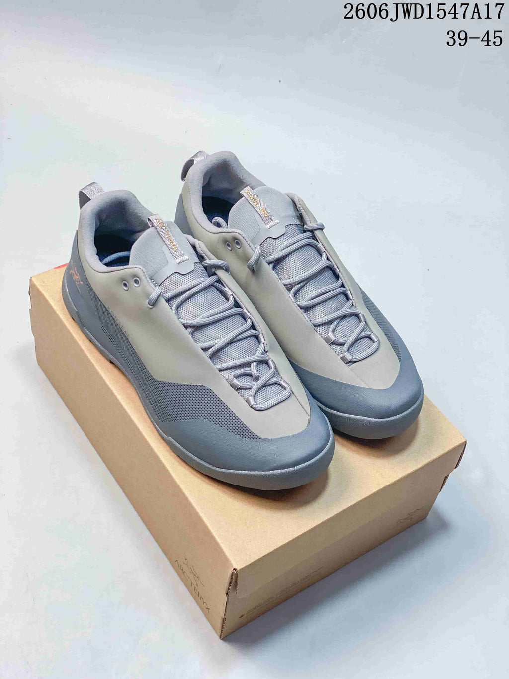 Pair of grey and blue-grey Arc'teryx Konseal low-top shoes on a box