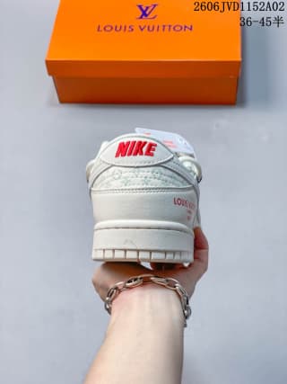 Rear view of the white sneaker showing red Nike branding, stitched heel construction, and the orange shoe box behind it.