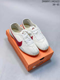 White Nike low-top sneakers with a red side Swoosh on an orange shoe box