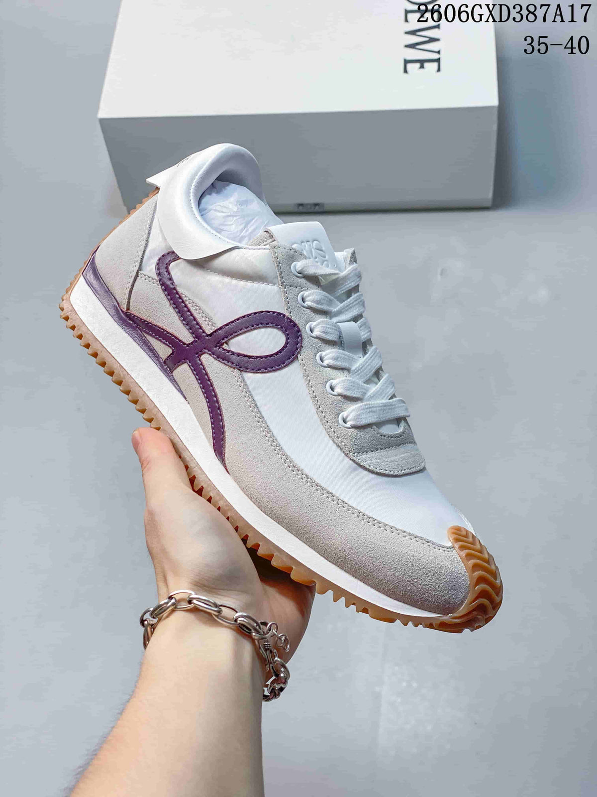 Angled side view of the white and gray sneaker with purple detailing and gum tread
