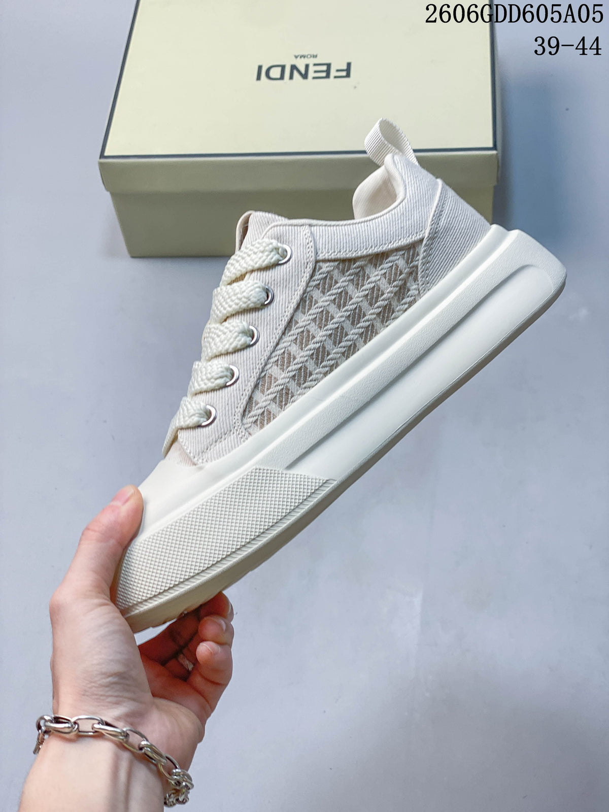 Side view of a cream lace-up sneaker with patterned panels and a thick sole