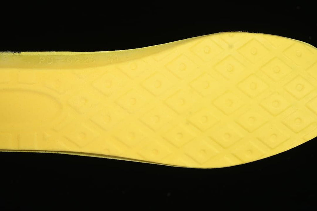 Close-up of the yellow outsole with a geometric tread pattern