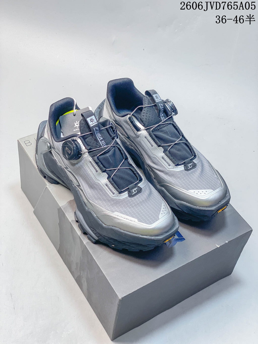 Pair of silver-gray Kailas FUGA BOA low-cut trail shoes with dial closures, shown on a box.
