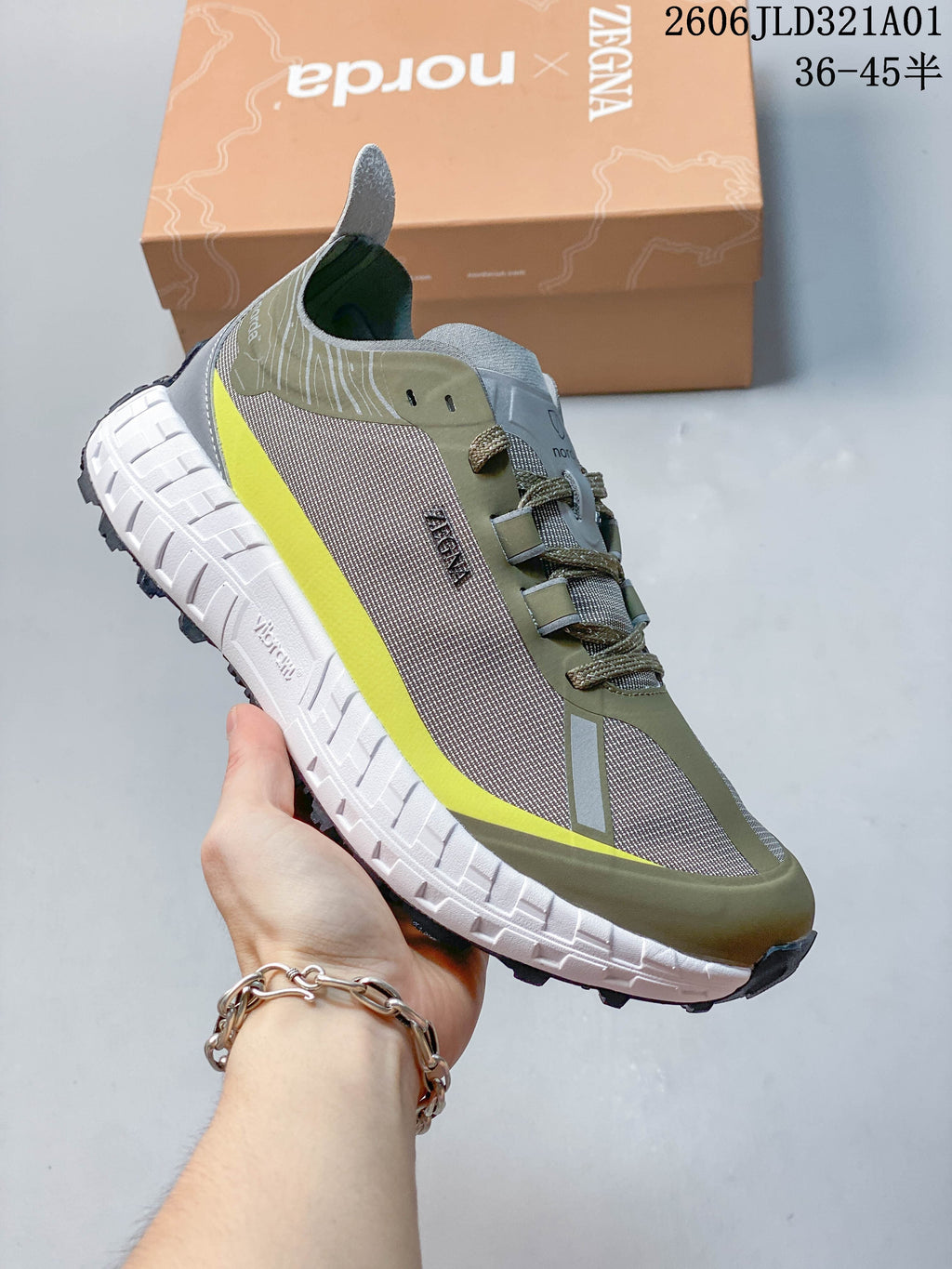 Angled side view of the shoe showing its olive green and grey upper and contrasting midsole.