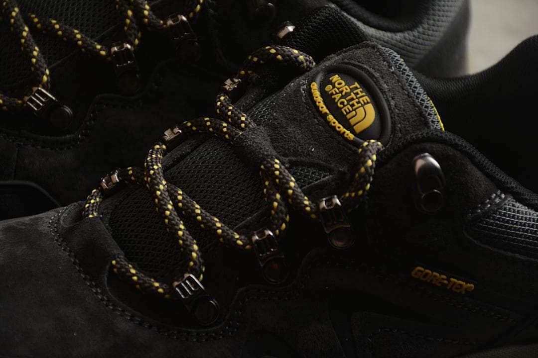 Detail of the hiking shoe's laces, metal-look hooks and tongue logo.