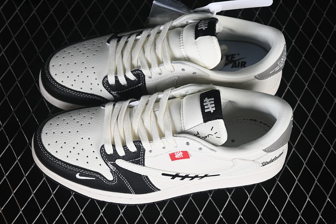 Pair of off-white, black, and grey low-top sneakers shown from above, with perforated toe panels and graphic side details.