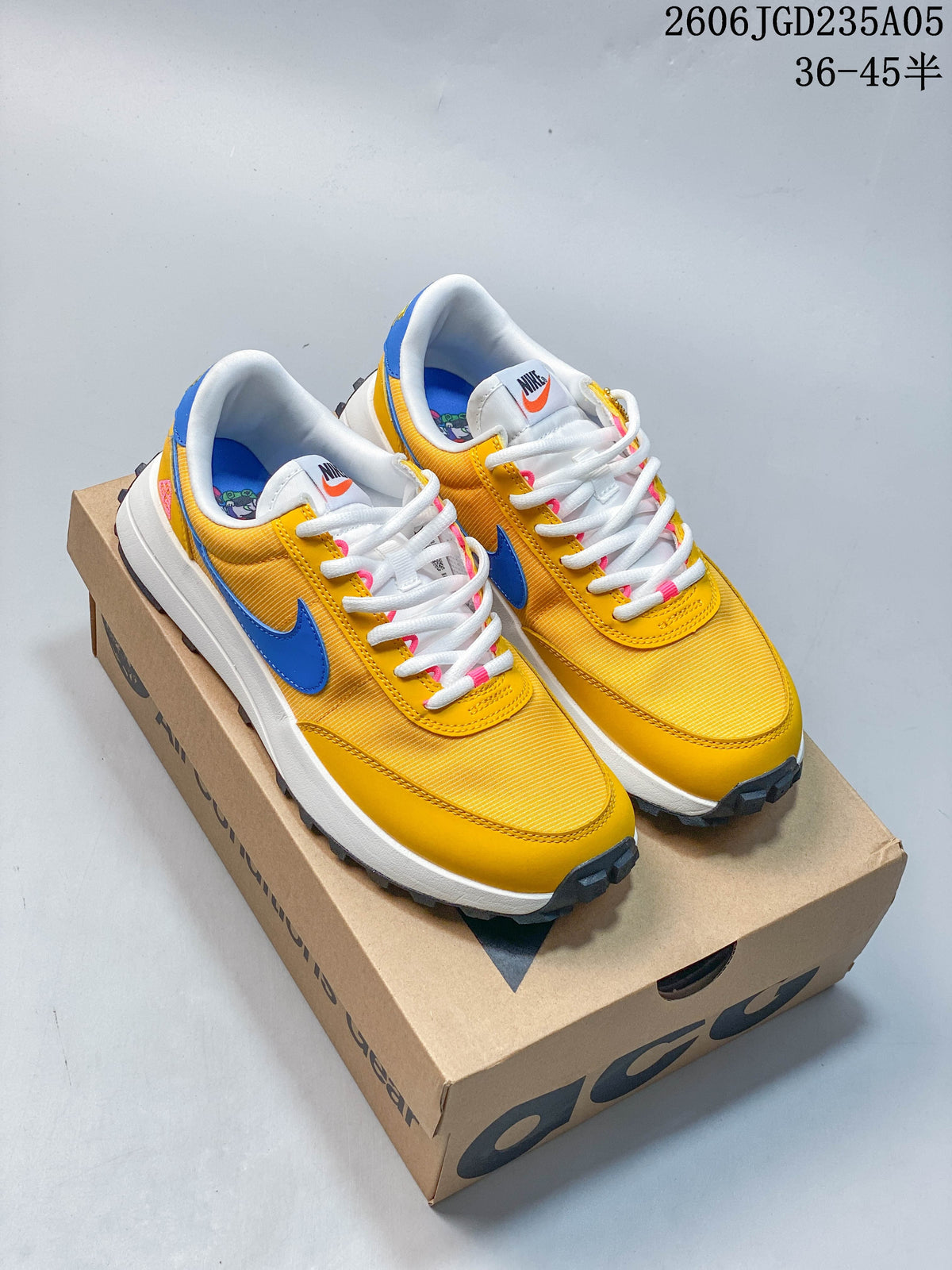 Pair of yellow and blue Nike ACG low-top shoes displayed on a shoebox