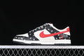 Side view of a black, white, and red low-top Nike Dunk sneaker with patterned overlays and laces.