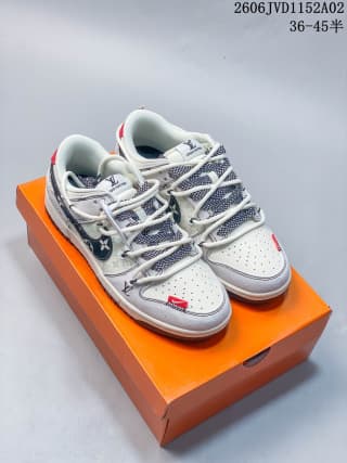 Pair of white and gray Louis Vuitton x Nike Dunk Low sneakers displayed on an orange box.