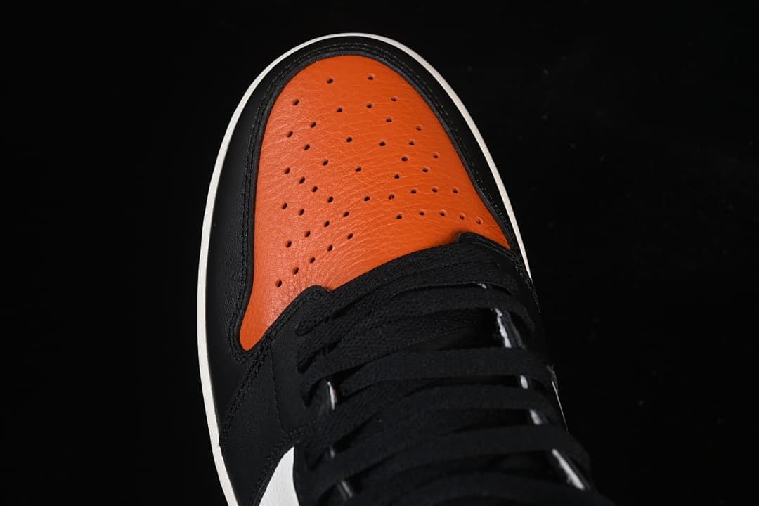 Top view of the orange perforated toe and black laces