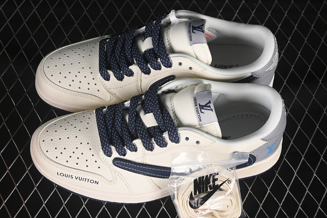 Overhead view of a pair of cream low-top sneakers with dark laces and extra light-colored laces.