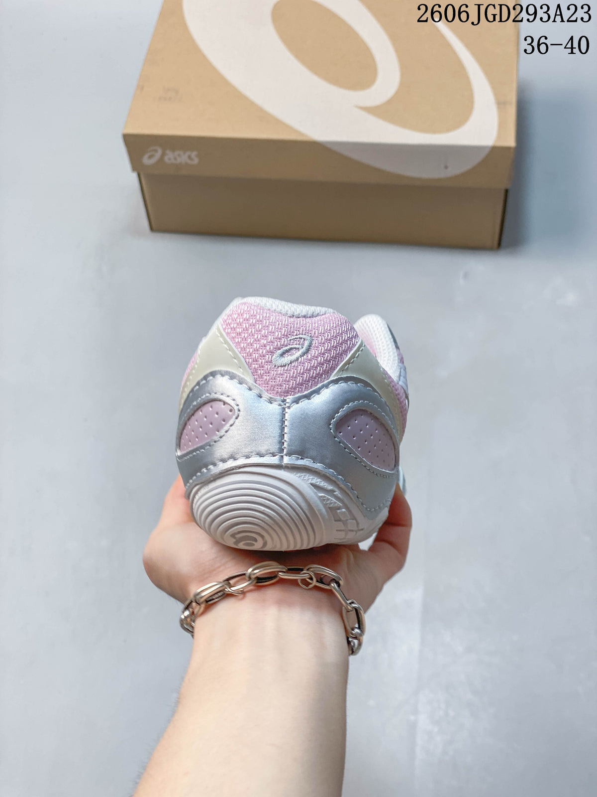 Rear view of a pink and silver sneaker showing the heel and outsole.