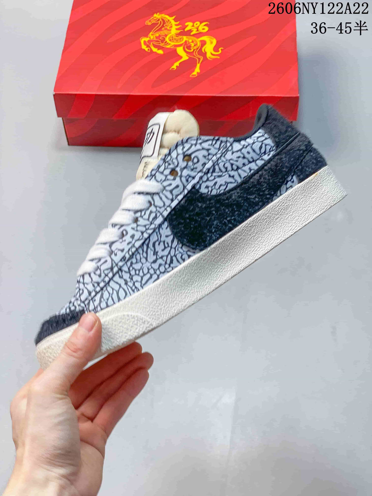 Side view of the patterned upper, dark overlay, and off-white sole