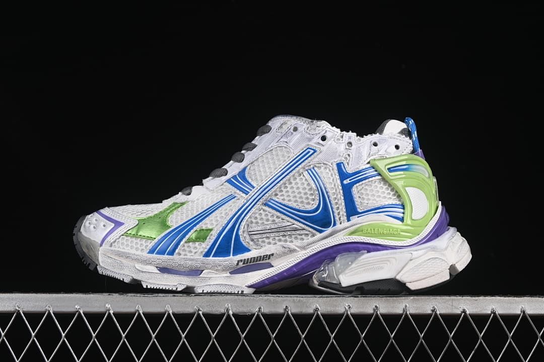 Side view of the white sneaker with blue, green, and purple accents