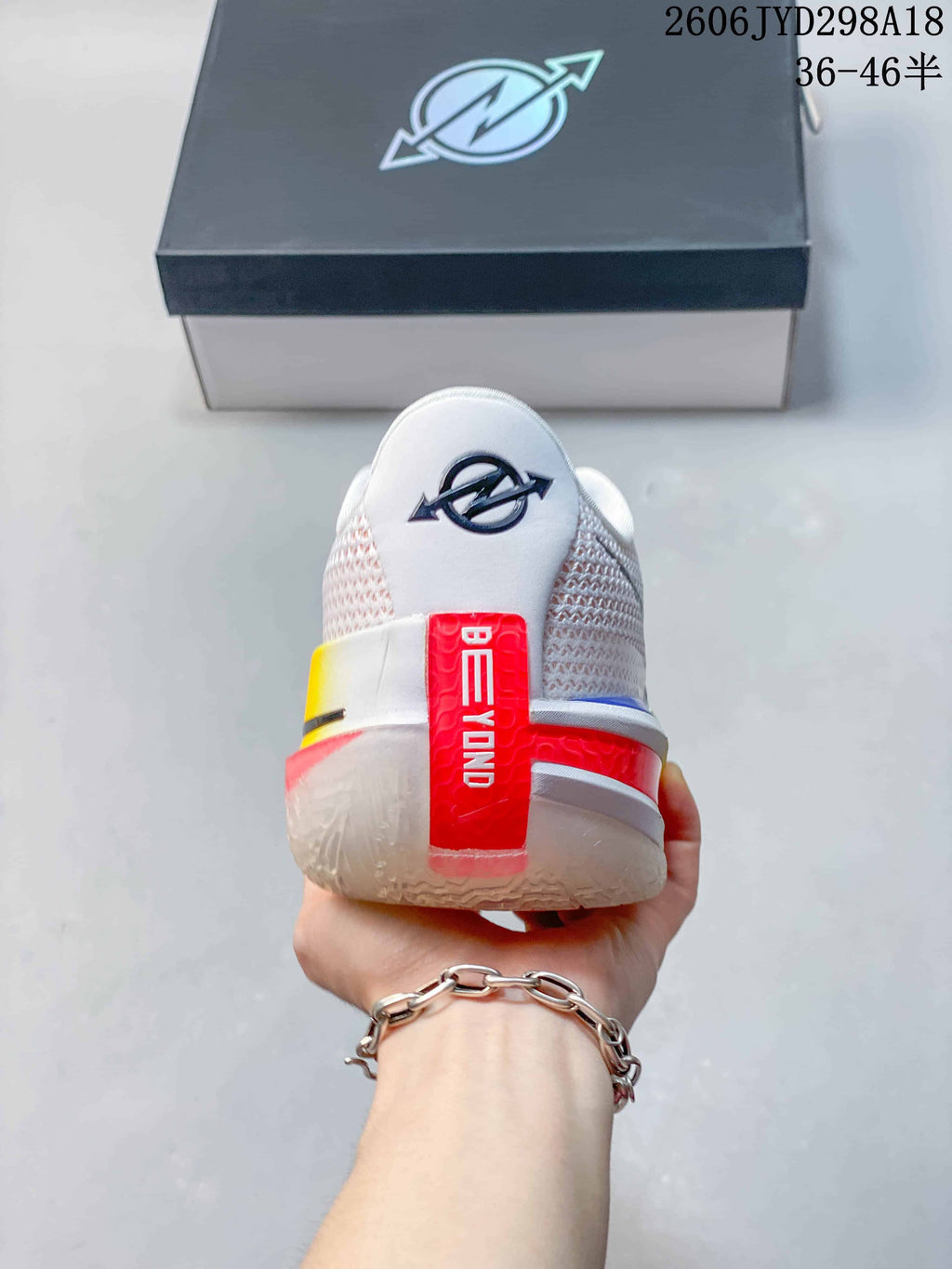 Rear view of the shoe showing white mesh-like panels and red heel accents.