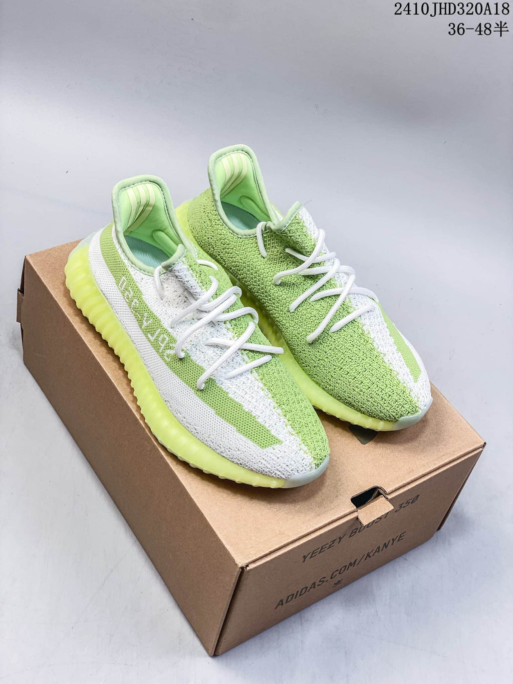 Pair of green and white Yeezy Boost 350 V2 sneakers on a box