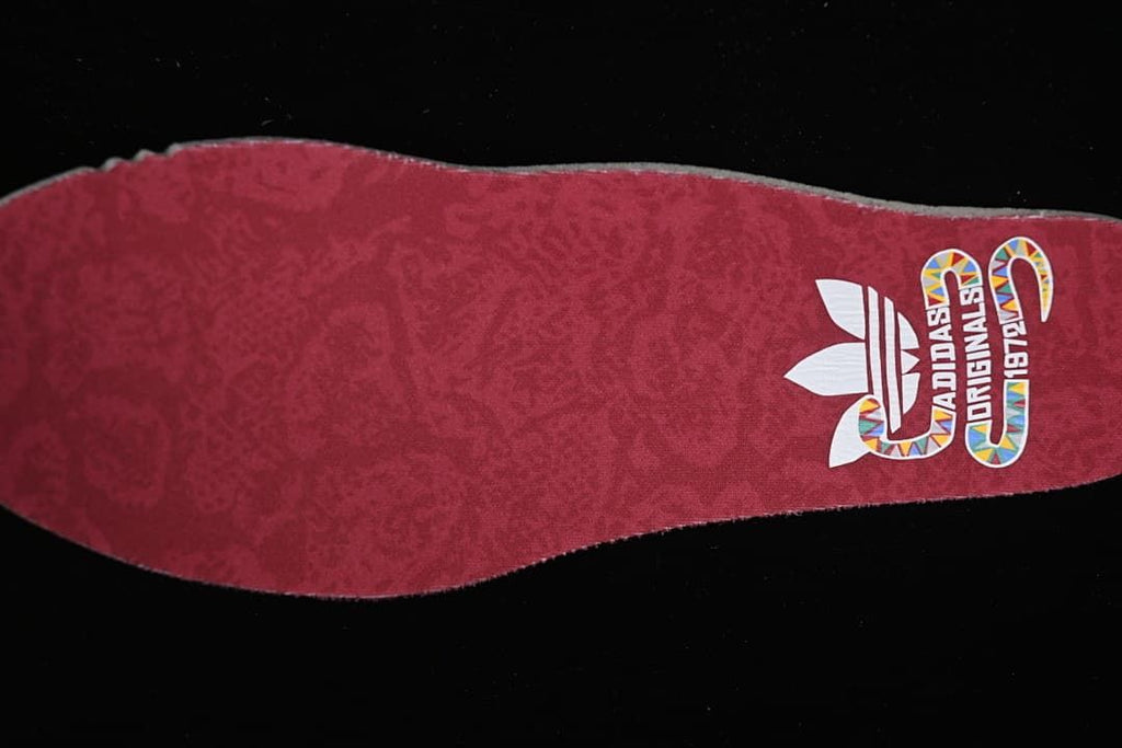 Red insole with adidas Originals branding and colorful graphic details
