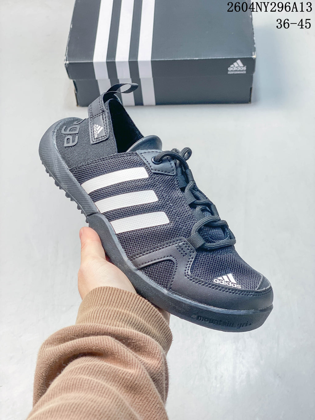 Close-up of a dark gray adidas TERREX shoe with white stripes and lace-up fastening.
