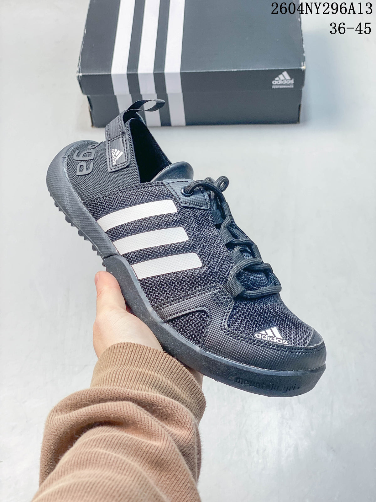 Close-up of a dark gray adidas TERREX shoe with white stripes and lace-up fastening.