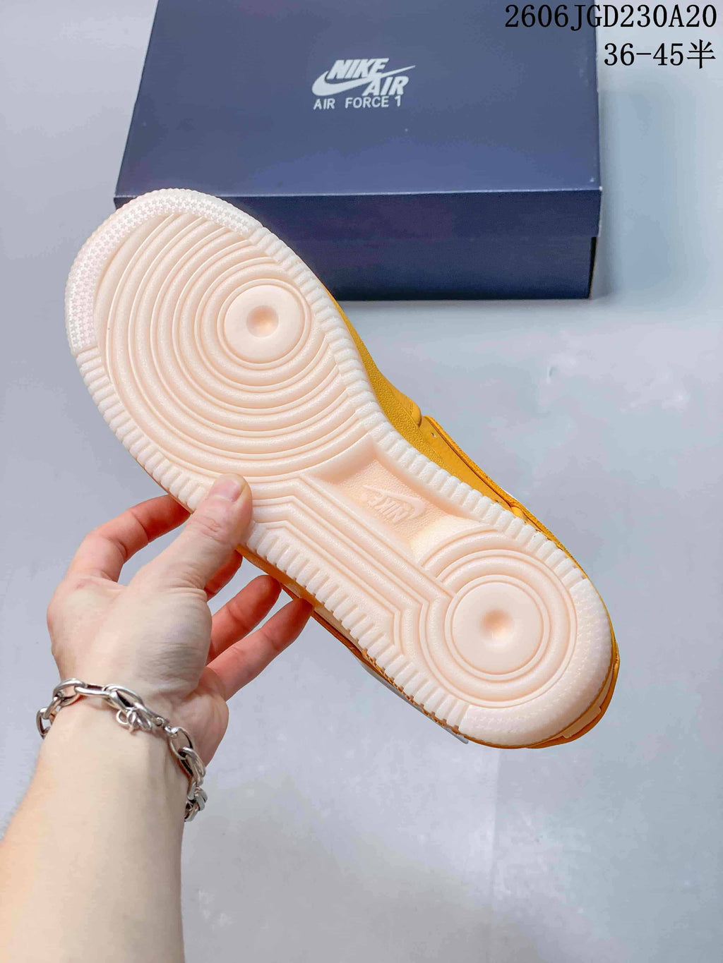 Underside of a yellow Nike Air Force 1 sneaker showing its white outsole