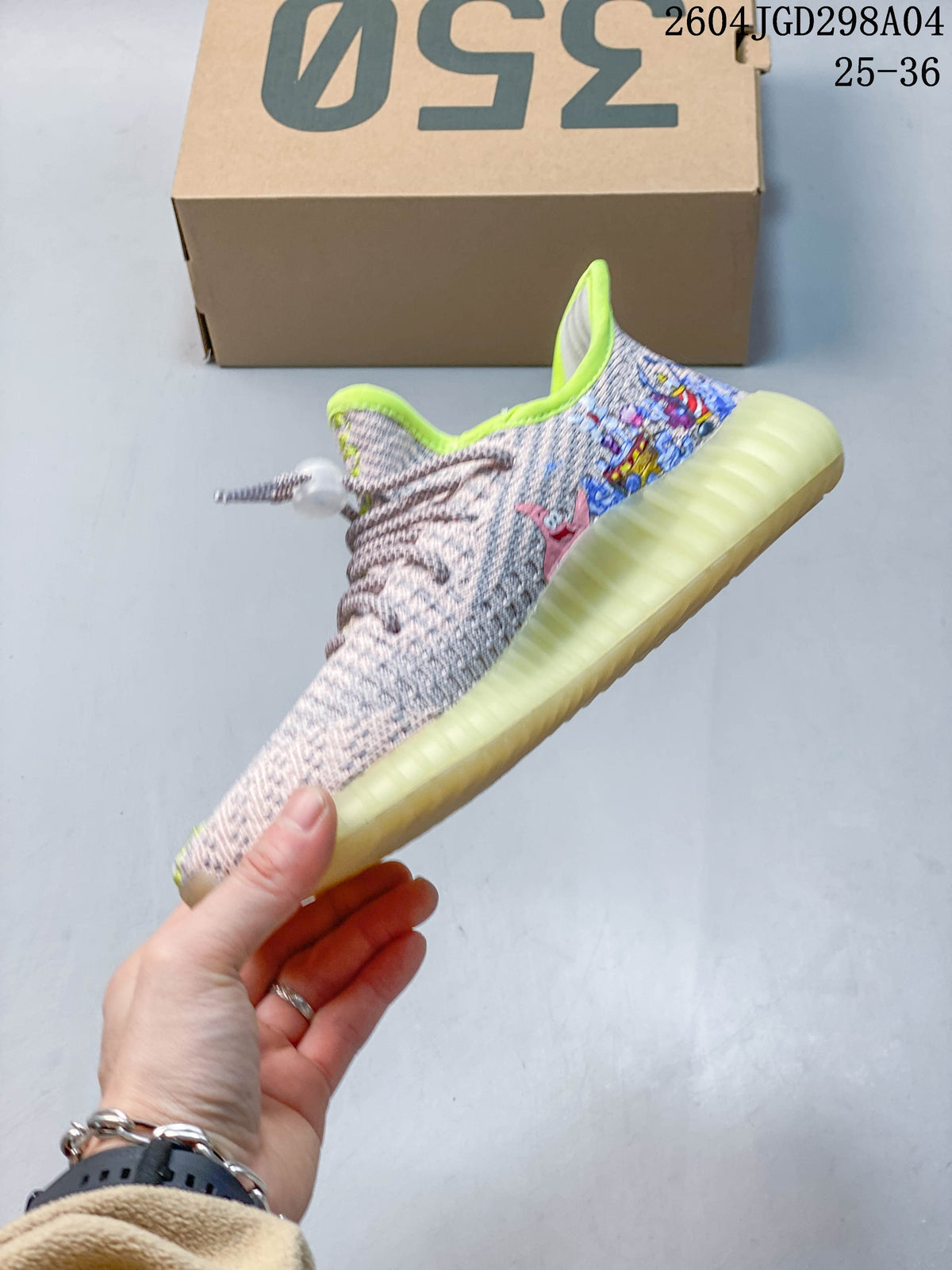 Side profile of the sneaker with cartoon graphics, patterned laces, and a translucent pale-yellow sole.