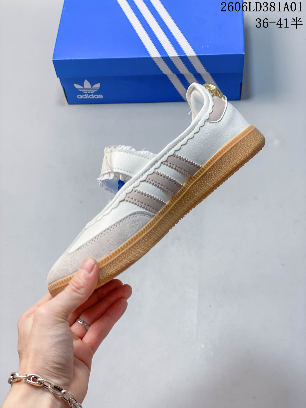 Side view of an Adidas Samba Jane sneaker with contrast stripes, a strap closure, and a gum-colored sole.