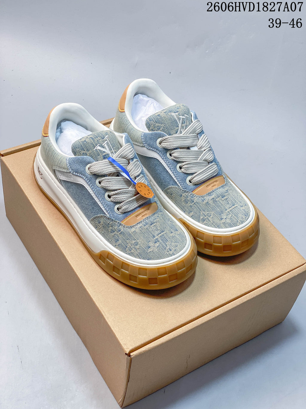 Pair of blue denim-style Louis Vuitton low-top sneakers with cream laces, tan accents, white midsoles, and gum-colored outsoles.