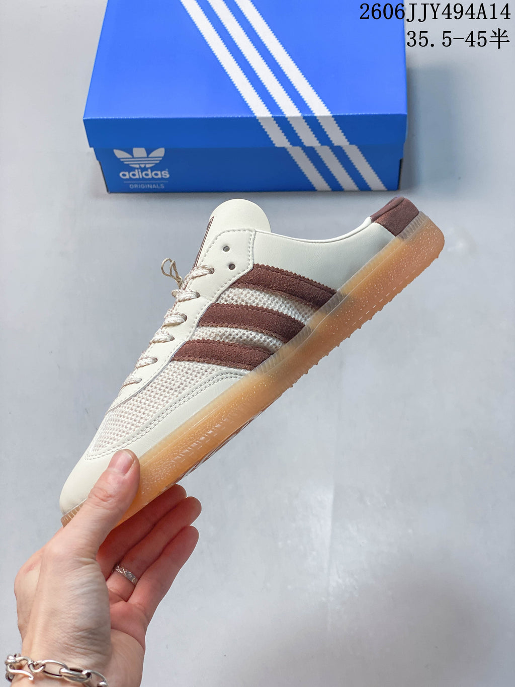 Side view of the cream and brown lace-up mule sneaker.