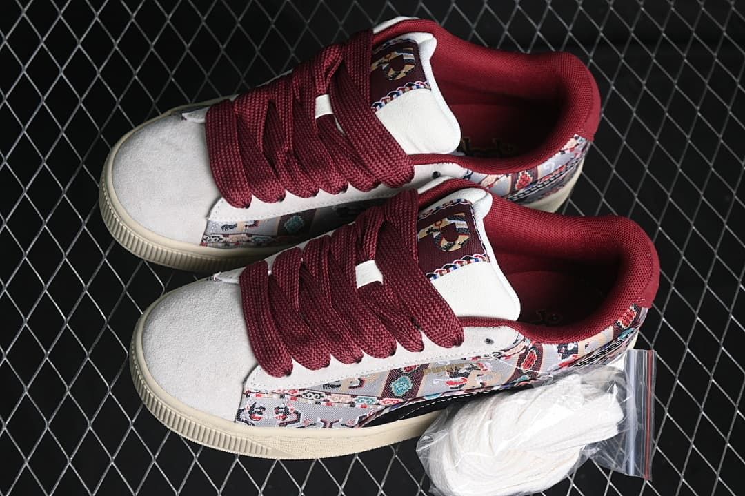 Pair of patterned low-top sneakers with burgundy laces and an extra set of light-colored laces